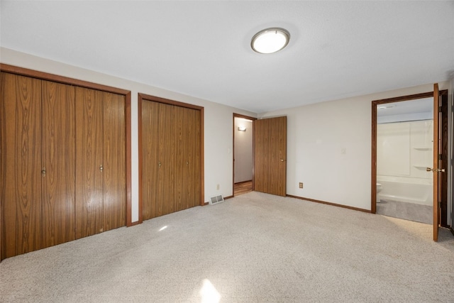 212 4th St SW, Mount Vernon, IA 52314 - unfurnished bedroom with carpet, multiple closets, and ensuite bath