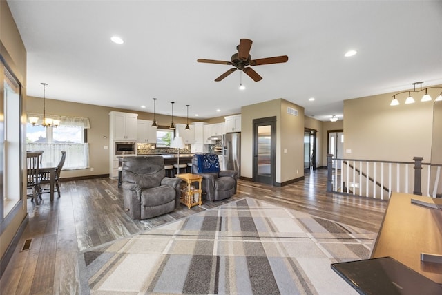 3363 Southridge Dr, Amana, IA 52203 - living room featuring dark wood finished floors, a ceiling fan, recessed lighting, and a chandelier