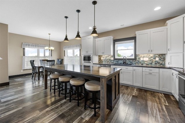 3363 Southridge Dr, Amana, IA 52203 - kitchen with a chandelier, backsplash, healthy amount of natural light, stainless steel microwave, and recessed lighting