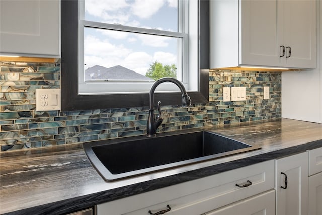 3363 Southridge Dr, Amana, IA 52203 - kitchen with dark countertops, decorative backsplash, and white cabinetry