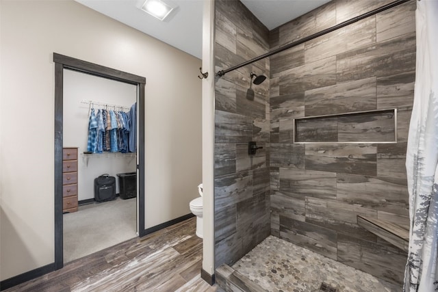 3363 Southridge Dr, Amana, IA 52203 - full bath with a tile shower, a spacious closet, and wood finished floors