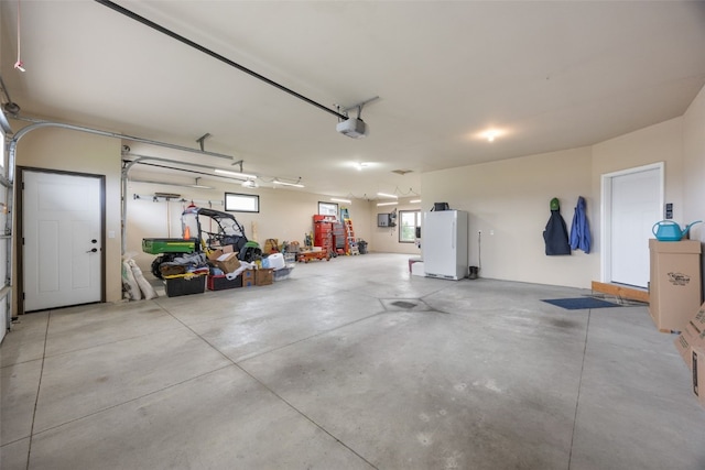 3363 Southridge Dr, Amana, IA 52203 - garage with freestanding refrigerator and a garage door opener