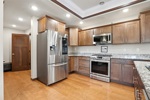 1102 S St, Urbana, IA 52345 - kitchen with appliances with stainless steel finishes, light wood-style floors, recessed lighting, and light stone countertops