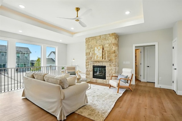 1002 Croell Ave, Tiffin, IA 52340 - living area featuring a raised ceiling, a ceiling fan, light wood finished floors, a stone fireplace, and recessed lighting
