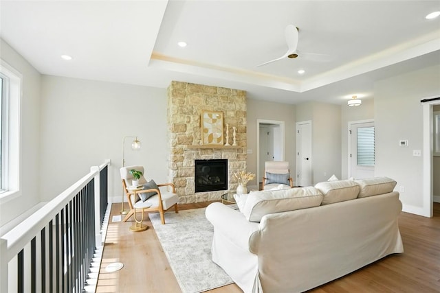 1002 Croell Ave, Tiffin, IA 52340 - living area with a raised ceiling, wood finished floors, a ceiling fan, a fireplace, and recessed lighting
