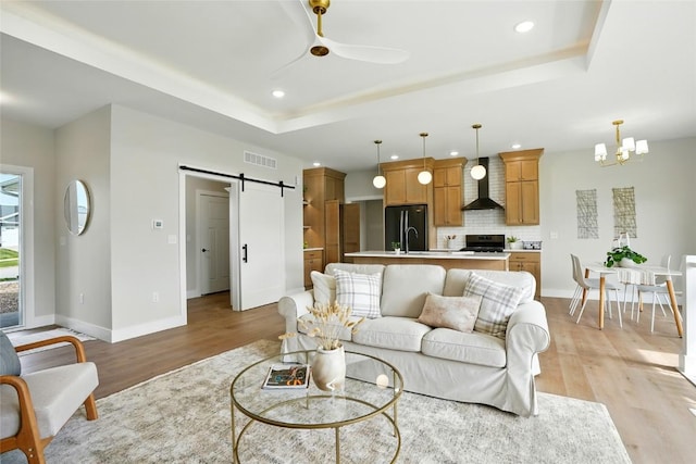 1002 Croell Ave, Tiffin, IA 52340 - living room featuring a tray ceiling, a barn door, light wood-style floors, a ceiling fan, and recessed lighting
