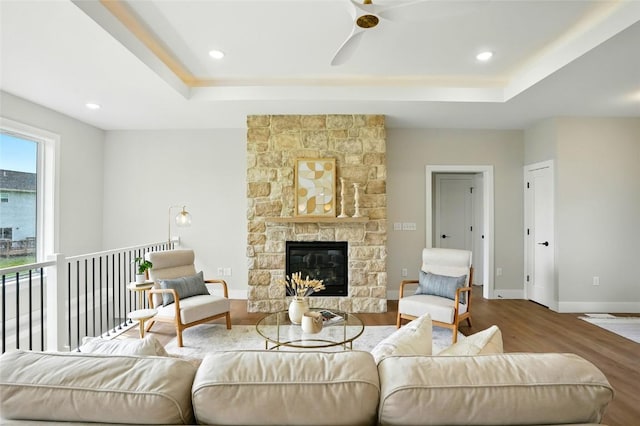 1002 Croell Ave, Tiffin, IA 52340 - living area featuring a tray ceiling, a ceiling fan, wood finished floors, a stone fireplace, and recessed lighting