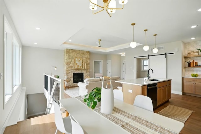 1002 Croell Ave, Tiffin, IA 52340 - dining area featuring a barn door, dark wood-style flooring, recessed lighting, a stone fireplace, and a ceiling fan