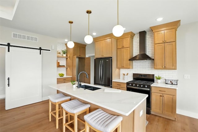 1002 Croell Ave, Tiffin, IA 52340 - kitchen featuring appliances with stainless steel finishes, wall chimney exhaust hood, light wood-style floors, decorative backsplash, and recessed lighting