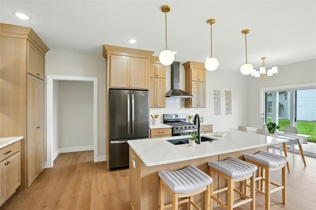 1002 Croell Ave, Tiffin, IA 52340 - kitchen with stainless steel appliances, wall chimney exhaust hood, backsplash, light wood finished floors, and a chandelier