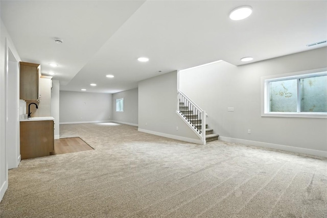 1002 Croell Ave, Tiffin, IA 52340 - below grade area with light colored carpet, stairs, and recessed lighting