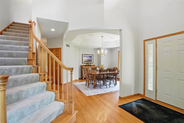 4317 Indian Tl NE, Solon, IA 52333 - entryway with light wood-type flooring, stairway, a chandelier, and a raised ceiling