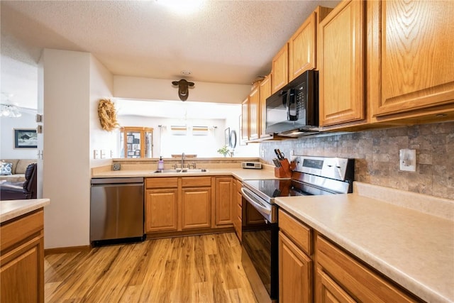 4593 Spoonbill Ct, Marion, IA 52302 - kitchen featuring stainless steel appliances, light wood-style flooring, backsplash, light countertops, and a textured ceiling