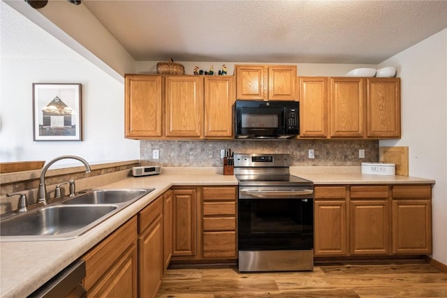 4593 Spoonbill Ct, Marion, IA 52302 - kitchen with appliances with stainless steel finishes, light wood-style flooring, tasteful backsplash, light countertops, and a textured ceiling