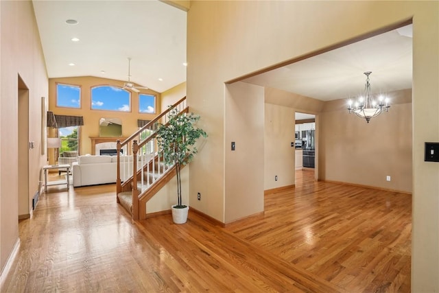 5515 W Mustang Rd NE, Cedar Rapids, IA 52411 - foyer with wood finished floors, a ceiling fan, a fireplace, a chandelier, and stairway