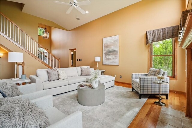 5515 W Mustang Rd NE, Cedar Rapids, IA 52411 - living area featuring wood finished floors, ceiling fan, high vaulted ceiling, and stairway