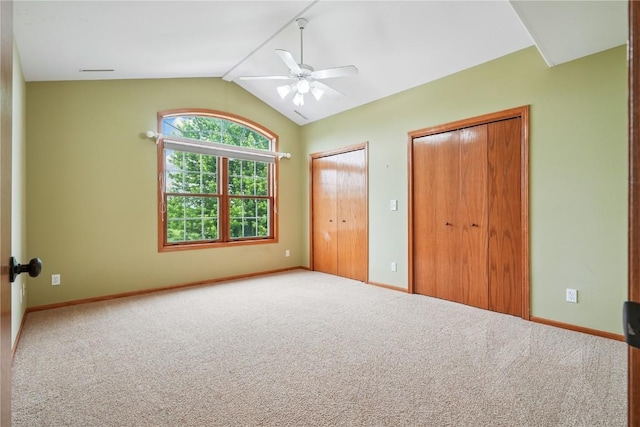 5515 W Mustang Rd NE, Cedar Rapids, IA 52411 - unfurnished bedroom with multiple closets, carpet floors, vaulted ceiling, and ceiling fan