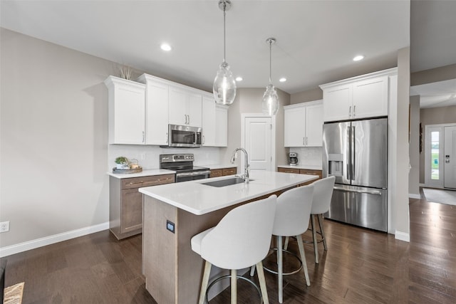 1953 Bowstring Dr, Marion, IA 52302 - kitchen with stainless steel appliances, recessed lighting, dark wood-style floors, an island with sink, and white cabinetry