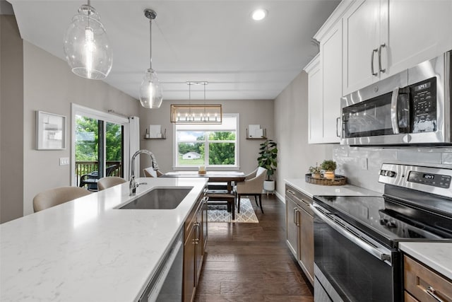 1953 Bowstring Dr, Marion, IA 52302 - kitchen with stainless steel appliances, dark wood-type flooring, white cabinets, light stone counters, and recessed lighting