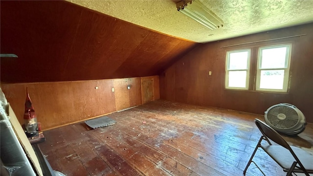419 21st St NE, Cedar Rapids, IA 52402 - additional living space featuring hardwood / wood-style flooring, vaulted ceiling, a textured ceiling, and wooden walls