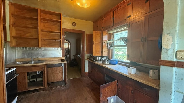 419 21st St NE, Cedar Rapids, IA 52402 - kitchen with stove, arched walkways, dark wood-style flooring, light countertops, and brown cabinetry