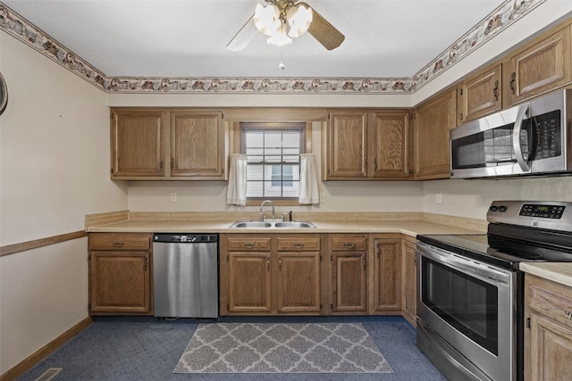 2540 Lori Dr SW, Cedar Rapids, IA 52404 - kitchen with appliances with stainless steel finishes, ceiling fan, light countertops, dark carpet, and brown cabinets