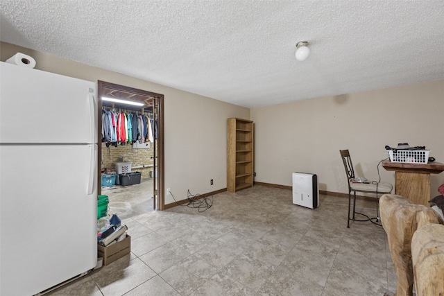 2540 Lori Dr SW, Cedar Rapids, IA 52404 - below grade area with freestanding refrigerator and a textured ceiling