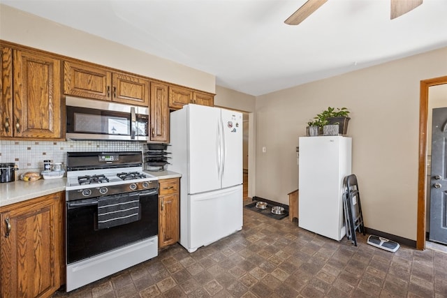 2469 1st St SW, Cedar Rapids, IA 52404 - kitchen with white appliances, brown cabinetry, light countertops, and tasteful backsplash