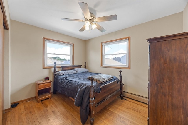 2469 1st St SW, Cedar Rapids, IA 52404 - bedroom featuring a baseboard radiator, light wood finished floors, and ceiling fan