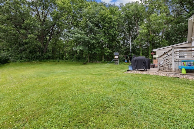 1428 Timber Ridge Trl NE, Solon, IA 52333 - view of grassy yard with a playground, view of scattered trees, and a wooden deck