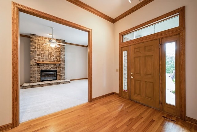 3519 Timber Ridge Trl NE, Cedar Rapids, IA 52411 - entryway with ceiling fan, crown molding, wood finished floors, and a brick fireplace
