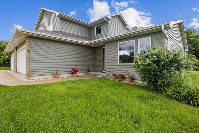 664 J Ave NE Unit A, Cedar Rapids, IA 52402 - rear view of house featuring a yard, a garage, and driveway