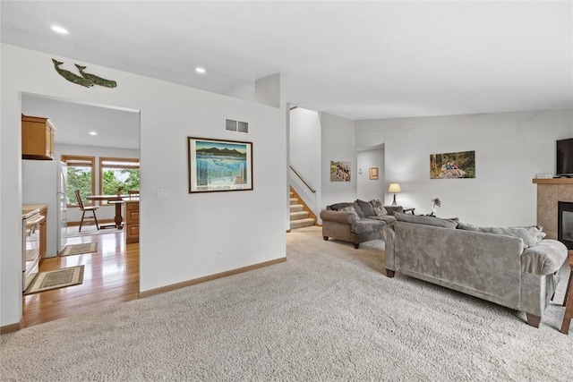664 J Ave NE Unit A, Cedar Rapids, IA 52402 - living area with carpet, stairs, recessed lighting, a fireplace, and wood finished floors