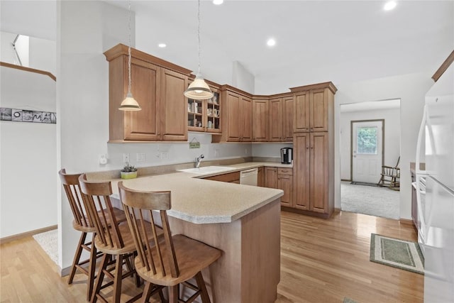 664 J Ave NE Unit A, Cedar Rapids, IA 52402 - kitchen with white appliances, a peninsula, a kitchen bar, light wood-type flooring, and glass insert cabinets