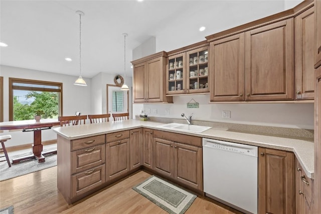 664 J Ave NE Unit A, Cedar Rapids, IA 52402 - kitchen featuring dishwasher, a peninsula, glass insert cabinets, light wood-style flooring, and decorative light fixtures