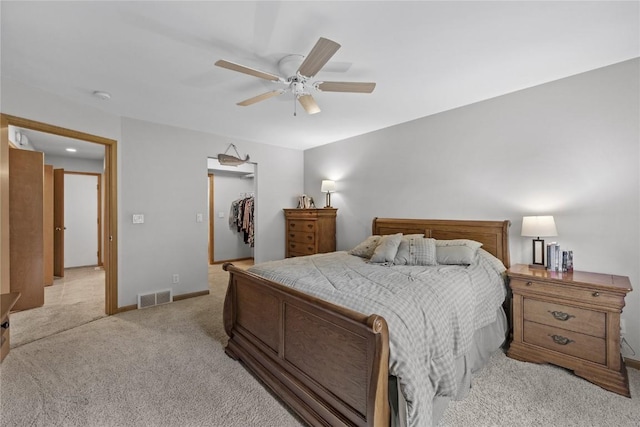 664 J Ave NE Unit A, Cedar Rapids, IA 52402 - bedroom featuring light colored carpet, a closet, a walk in closet, and a ceiling fan