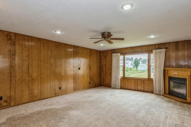 5660 Briarwood St SW, Cedar Rapids, IA 52401 - unfurnished living room featuring a ceiling fan, carpet floors, a glass covered fireplace, wooden walls, and recessed lighting