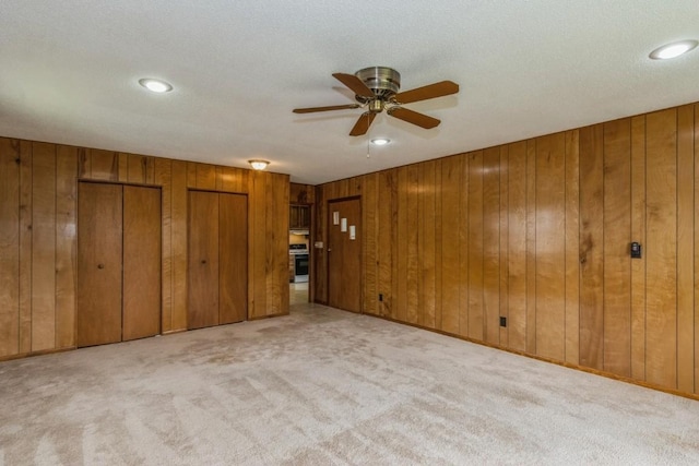5660 Briarwood St SW, Cedar Rapids, IA 52401 - unfurnished living room with a ceiling fan, carpet flooring, wood walls, and recessed lighting