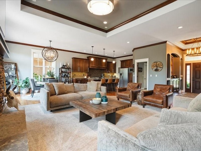 4390 Flagstick Dr, Marion, IA 52302 - living area featuring a chandelier, ornamental molding, a tray ceiling, recessed lighting, and arched walkways