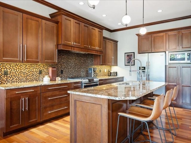 4390 Flagstick Dr, Marion, IA 52302 - kitchen featuring crown molding, appliances with stainless steel finishes, light wood finished floors, light stone counters, and backsplash