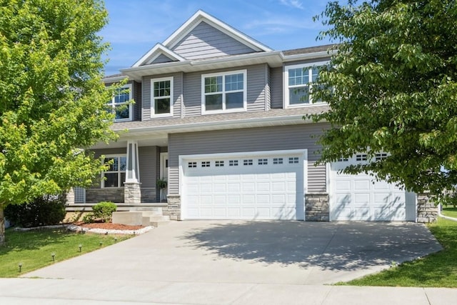 3076 Lower W Branch Rd, Iowa City, IA 52245 - view of front of home with a garage, concrete driveway, stone siding, and covered porch