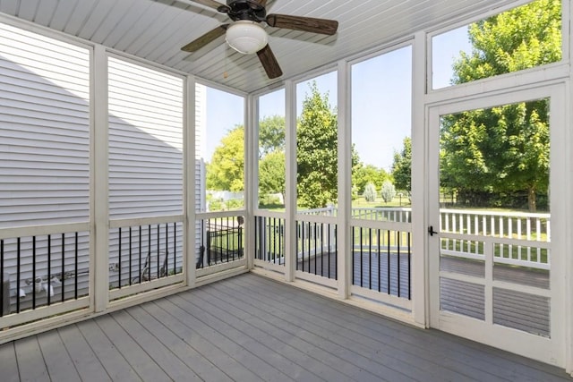 3076 Lower W Branch Rd, Iowa City, IA 52245 - unfurnished sunroom featuring a ceiling fan, a deck, and wood-type flooring