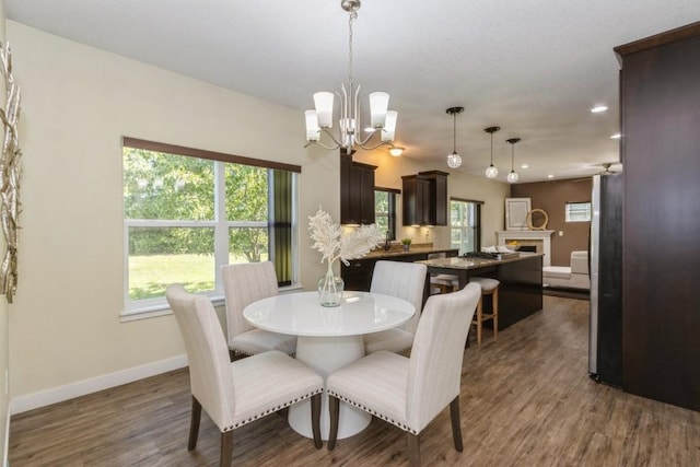 3076 Lower W Branch Rd, Iowa City, IA 52245 - dining room featuring dark wood-style floors, recessed lighting, a chandelier, and a fireplace