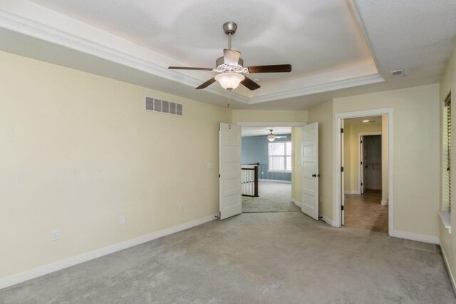 3076 Lower W Branch Rd, Iowa City, IA 52245 - unfurnished bedroom featuring light carpet, a raised ceiling, and a ceiling fan