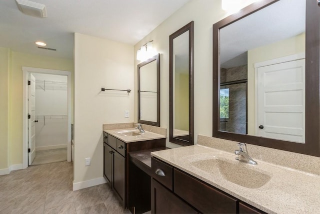 3076 Lower W Branch Rd, Iowa City, IA 52245 - bathroom with two vanities, a walk in closet, a stall shower, recessed lighting, and tile patterned floors