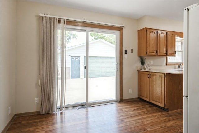 3624 Bel Air Dr SE, Cedar Rapids, IA 52403 - kitchen featuring wood finished floors, light countertops, and brown cabinets