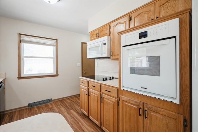 3624 Bel Air Dr SE, Cedar Rapids, IA 52403 - kitchen featuring white appliances, light wood finished floors, and light countertops