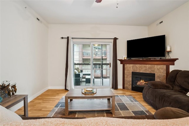 1848 W Benton St, Iowa City, IA 52246 - living room with wood finished floors, ceiling fan, and a tile fireplace