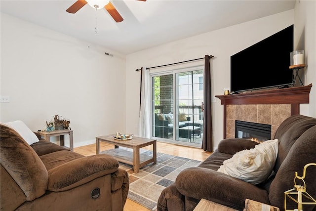 1848 W Benton St, Iowa City, IA 52246 - living area featuring ceiling fan, a tiled fireplace, and light wood-style flooring