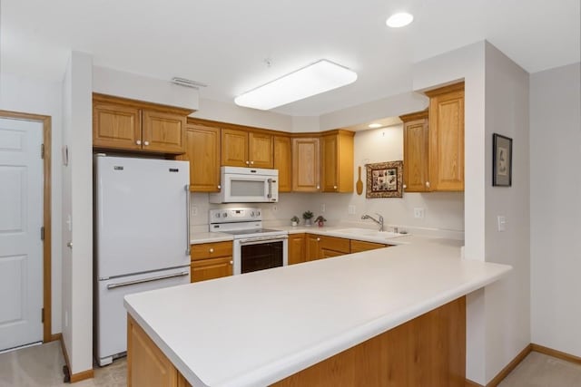2601 Hickory Trl Unit 1, Iowa City, IA 52245 - kitchen with white appliances, a peninsula, light countertops, brown cabinetry, and recessed lighting